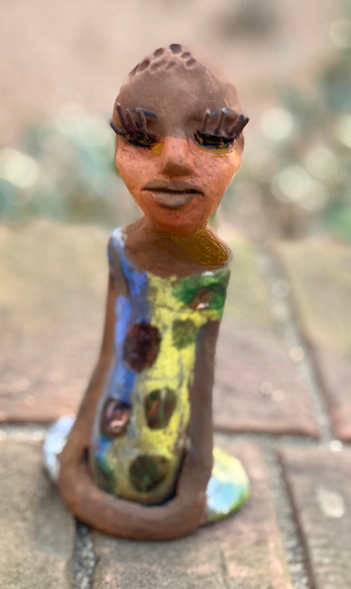 Adisa stands 7' x 4"x 2" and weighs 10.3 ozs. She has bright  dark eyes and a nice honey two tone brown complexion Her long trademark arms rest at her side. Adisa dress is a loving glossy blue and yellow mix with copper flashes.