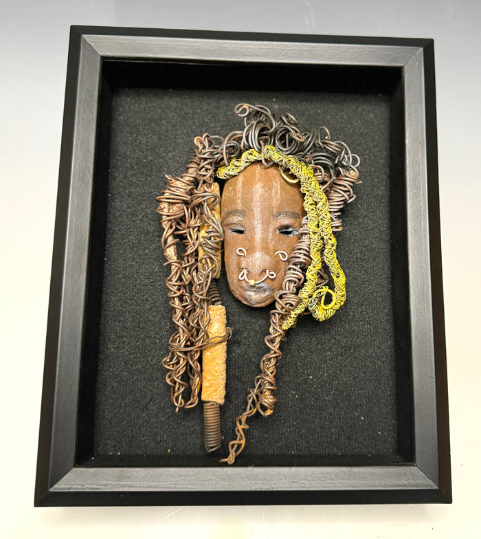 At 5" x 8" in size, Ike makes a stunning addition to walls, trees, and shadow boxes. His signature brown and amber braided hair is ornamented with handcrafted Raku beads, while his skin has a warm honey brown hue. Each piece is equipped with over 20 feet of top-notch 16 & 24-gauge wire in the hair. This fashionable sculpture will bring a modern flair to any room - simply place it in a shadow box and enjoy!