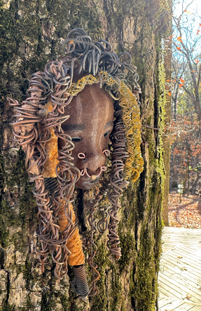 At 5" x 8" in size, Ike makes a stunning addition to walls, trees, and shadow boxes. His signature brown and amber braided hair is ornamented with handcrafted Raku beads, while his skin has a warm honey brown hue. Each piece is equipped with over 20 feet of top-notch 16 & 24-gauge wire in the hair. This fashionable sculpture will bring a modern flair to any room - simply place it in a shadow box and enjoy!
