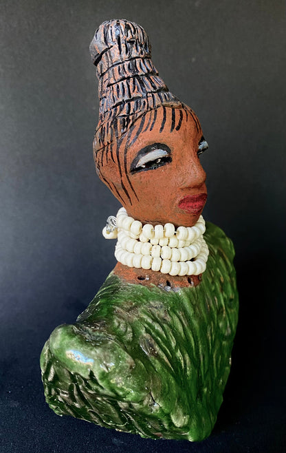 Meet Kayla!   Kayla looks ready  for an exciting evening out!  Kayla stands 6" x 5" x 3 and weighs 14 ozs. Kayla has a nice honey brown complexion and wears glasses. She wear etched clay hair styled in a bun. Kayla wears a textured white crackle robe. She is angelic! Kayla will make a great gift or starter piece from the Herdew Collection! Check out our Shipping and Return policy