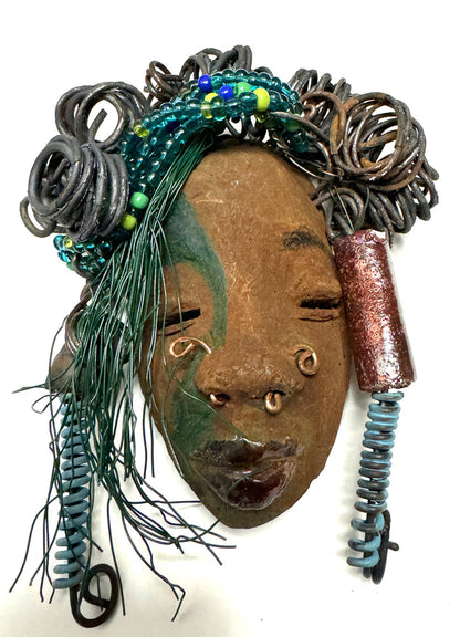 At 5" x 8" in size,  Marcel makes a stunning addition to walls, trees, and shadow boxes. His signature brown and amber braided hair is ornamented with handcrafted Raku beads, while his skin has a warm honey brown hue. Each piece is equipped with over 10 16 & 24-gauge wire in the hair. This fashionable sculpture will bring a modern flair to any room - simply place it in a shadow box and enjoy!