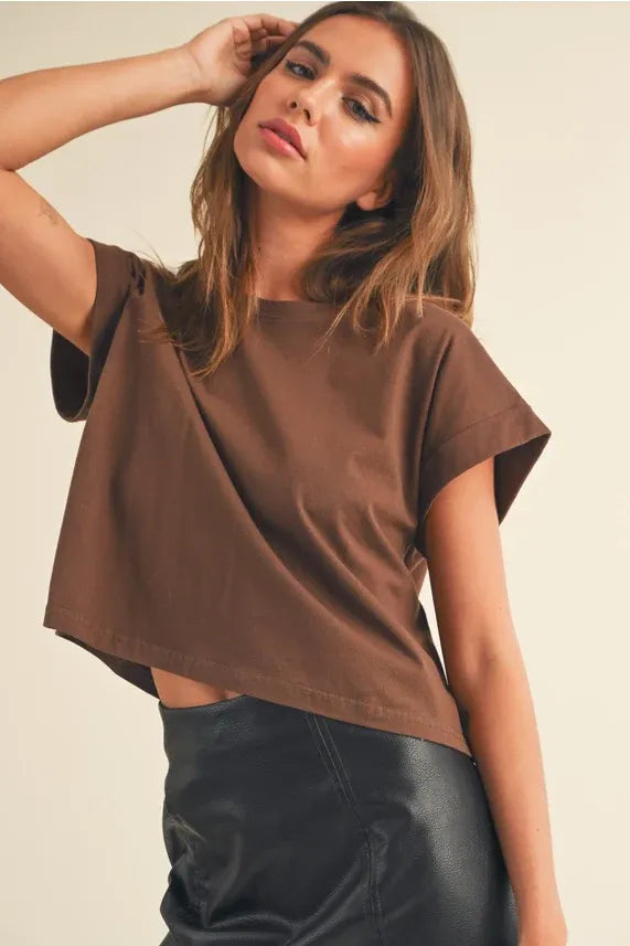 Women’s round neck cuffed short-sleeve crop top paired with a black faux leather skirt