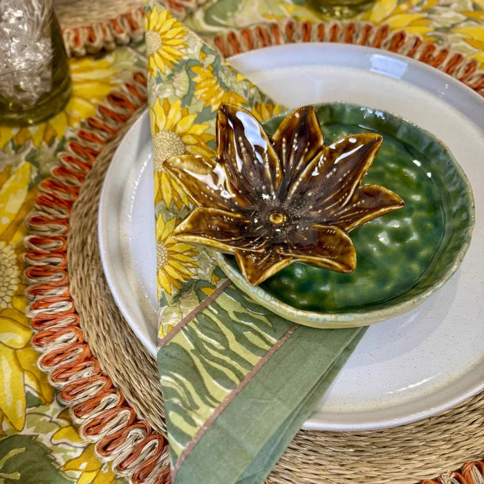 Ceramic brown lotus-shaped dish from STONEWARE FLOWER SHAPED DISH collection on a textured green bowl